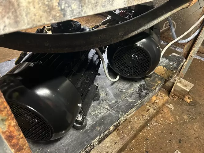 Rear view of Replacement electric motors fitted to multi-pump pressure washer system during repair at a malt house in Burton.